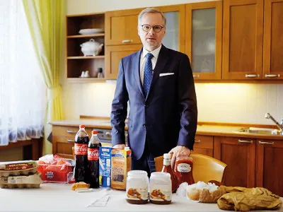 One man show.  Premiér Fiala v propagačním videu srovnává ceny potravin, které si nakoupil v německém a českém supermarketu.